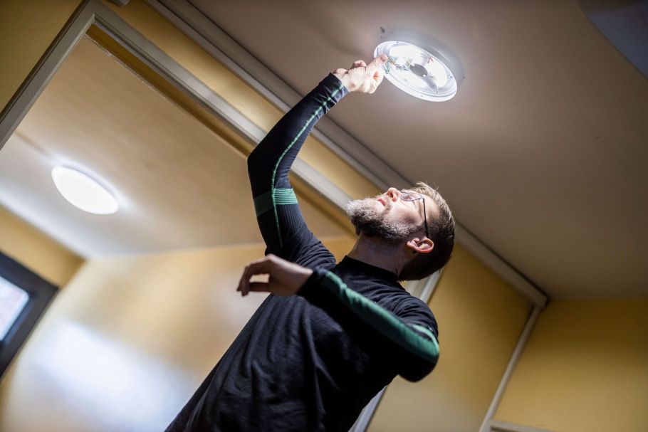 Elektriker skifter LED-belysning i fællesareal i en boligforening
